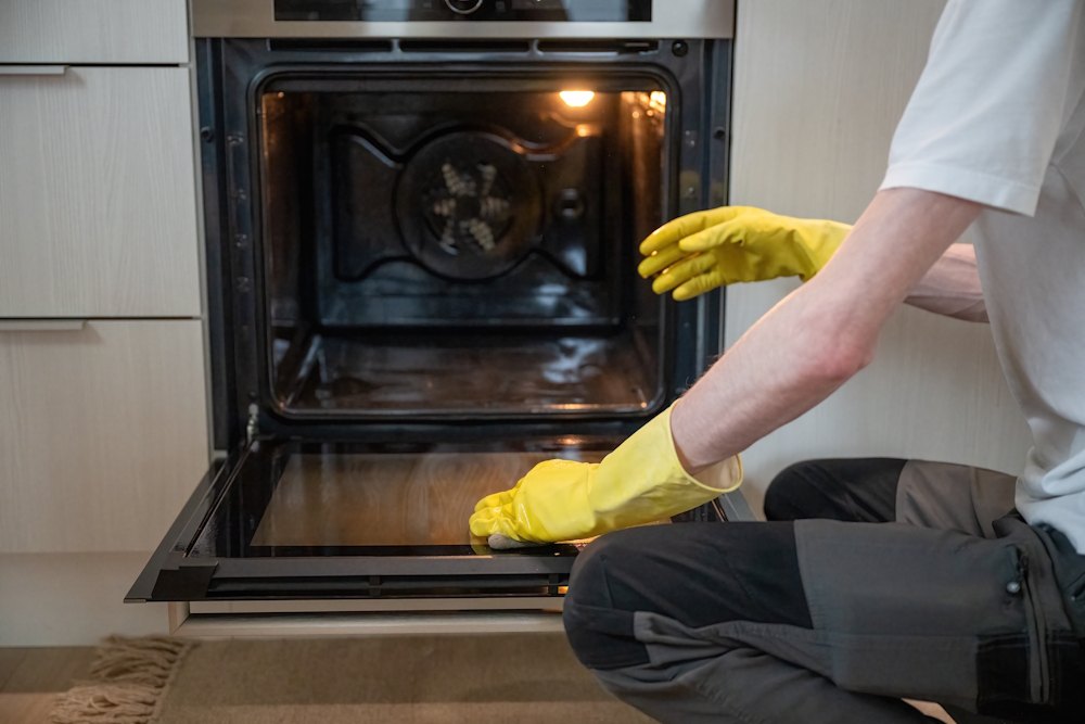 A man cleaning an oven